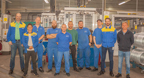 Acht Mitarbeiter von Michelin stehen mit ihren Managern in einer Halle. Foto: Michelin