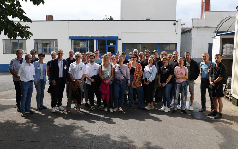 Menschengruppe steht auf dem Firmengelände des Lackherstellers Jansen. Foto: Jansen