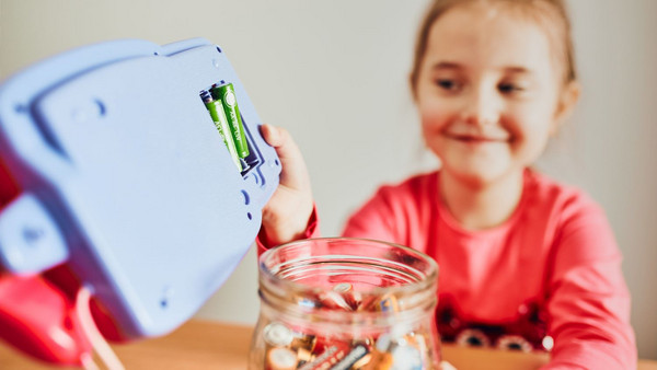 Mädchen sammelt Altbatterien aus einem Spielzeugauto ein. Foto: Przemek Klos