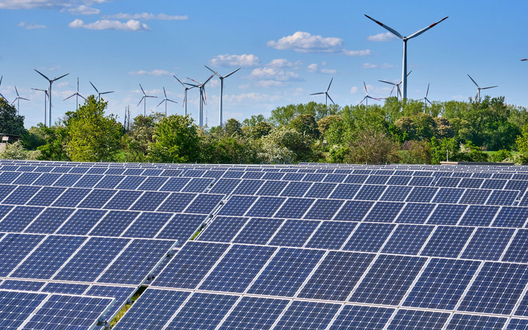 Large solar park with wind turbines at the horizon. elxeneize - stock.adobe.com