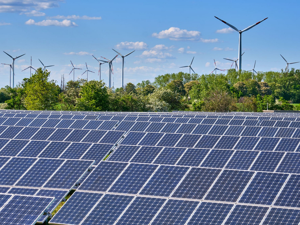 Large solar park with wind turbines at the horizon. elxeneize - stock.adobe.com