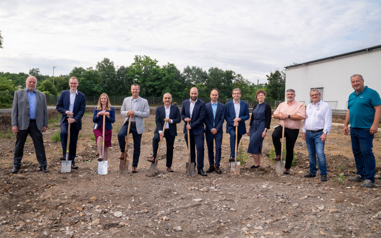 Personen, die auf dem Gelände des Campus Budenheim stehen und Spaten in der Hand halten. Foto: Budenheim 