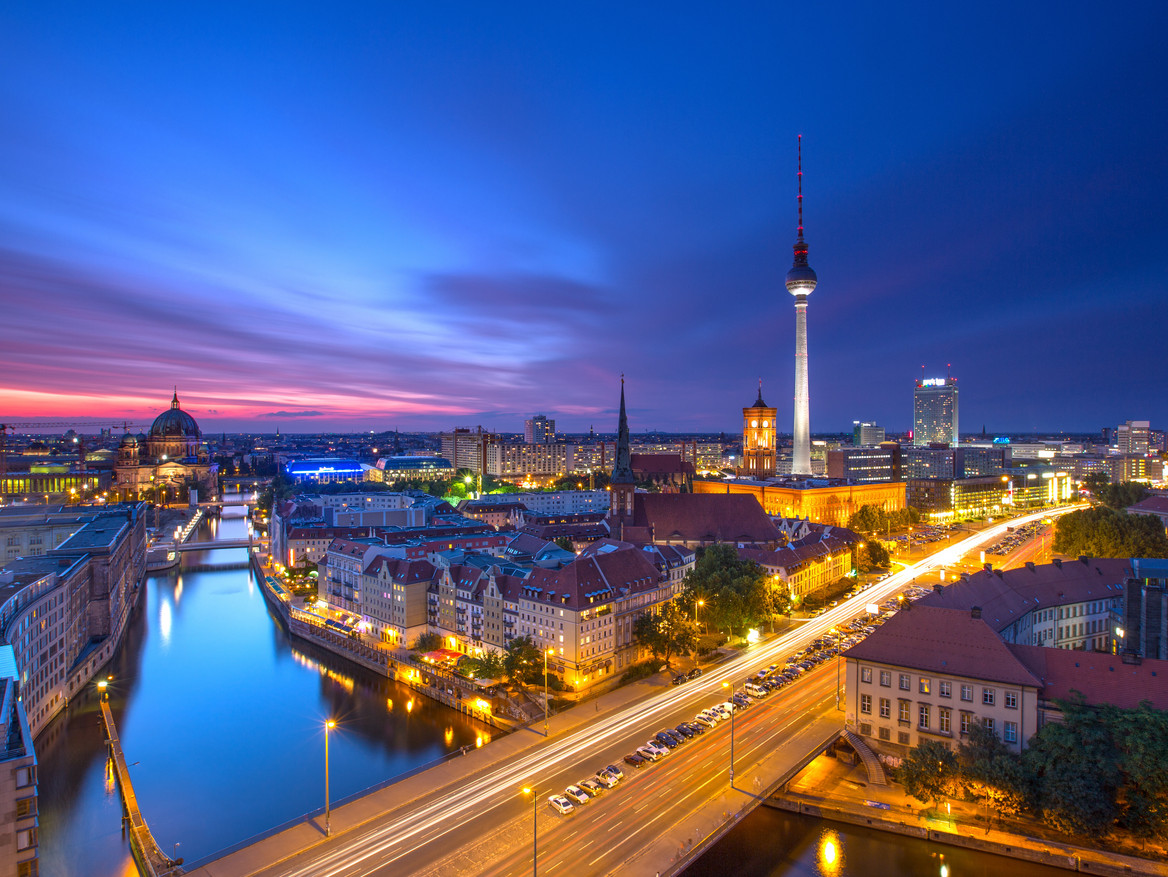 Der Berliner Fernsehturm und die Spree bei dunklem Himmel. 