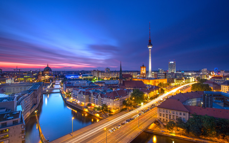 Der Berliner Fernsehturm und die Spree bei dunklem Himmel. 