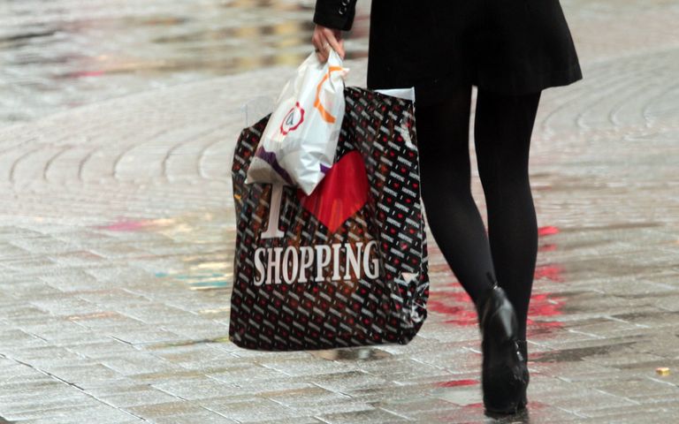 Eine Frau hält Einkaufstüten aus Plastik in den Händen