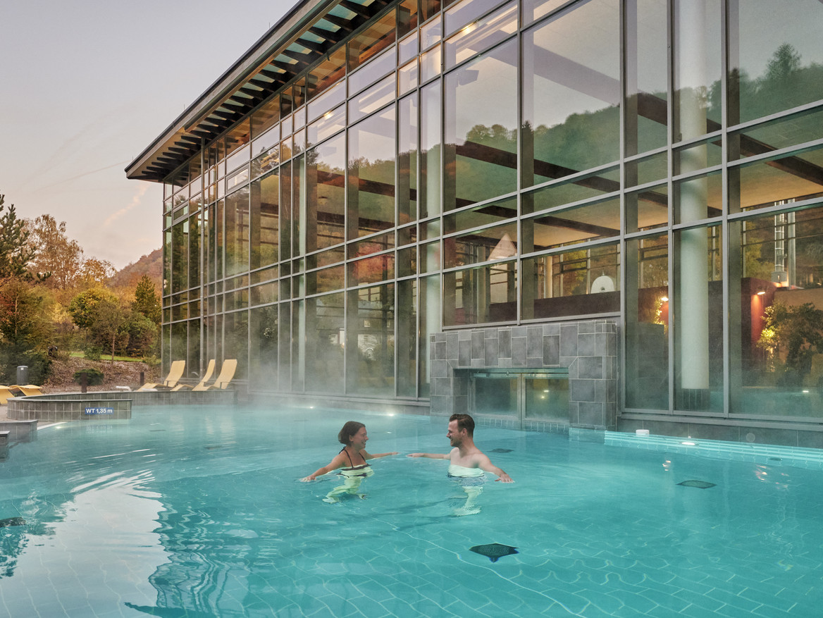 Außenbereich der Vulkaneifel-Therme in Bad Bertich, in dem ein Mann und eine Frau schwimmen. Foto: CC BY-SA Rheinland-Pfalz Tourismus GmbH/Florian Trykowski