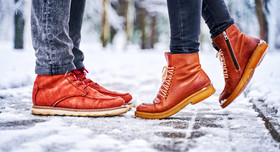 Zwei Menschen in Lederschuhen stehen im Schnee