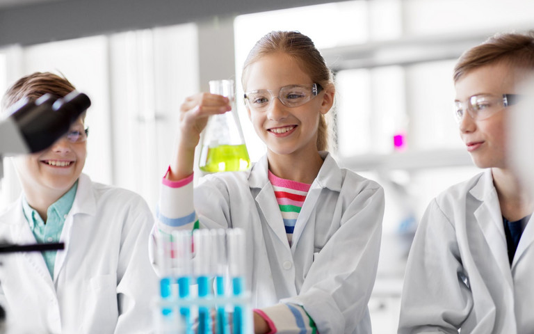 Drei Schulkinder bei Versuchen im Chemielabor. Foto: Syda Productions - stock.adobe.com